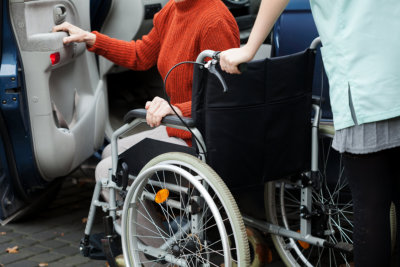 man/woman assisting senior in a wheelchair